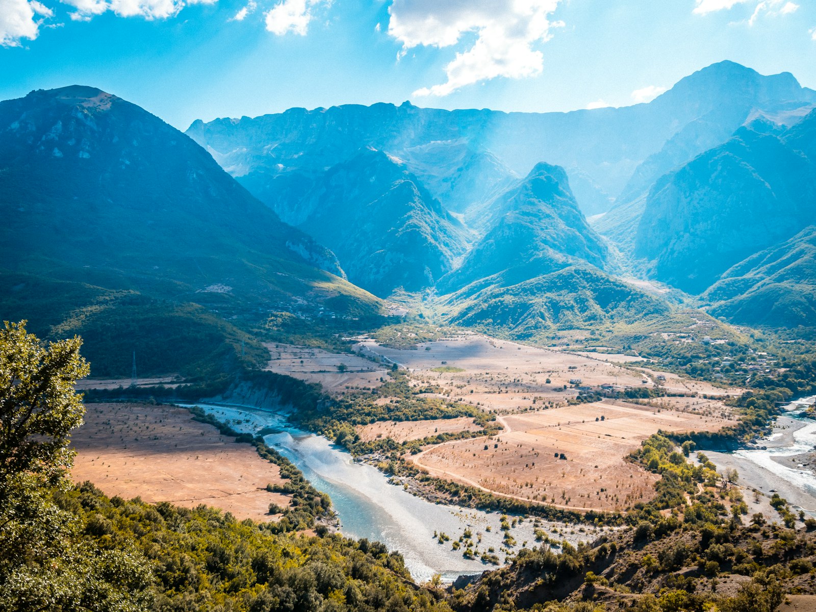 Mountains and a winding river through an Albanian valley — a classic road trip view
