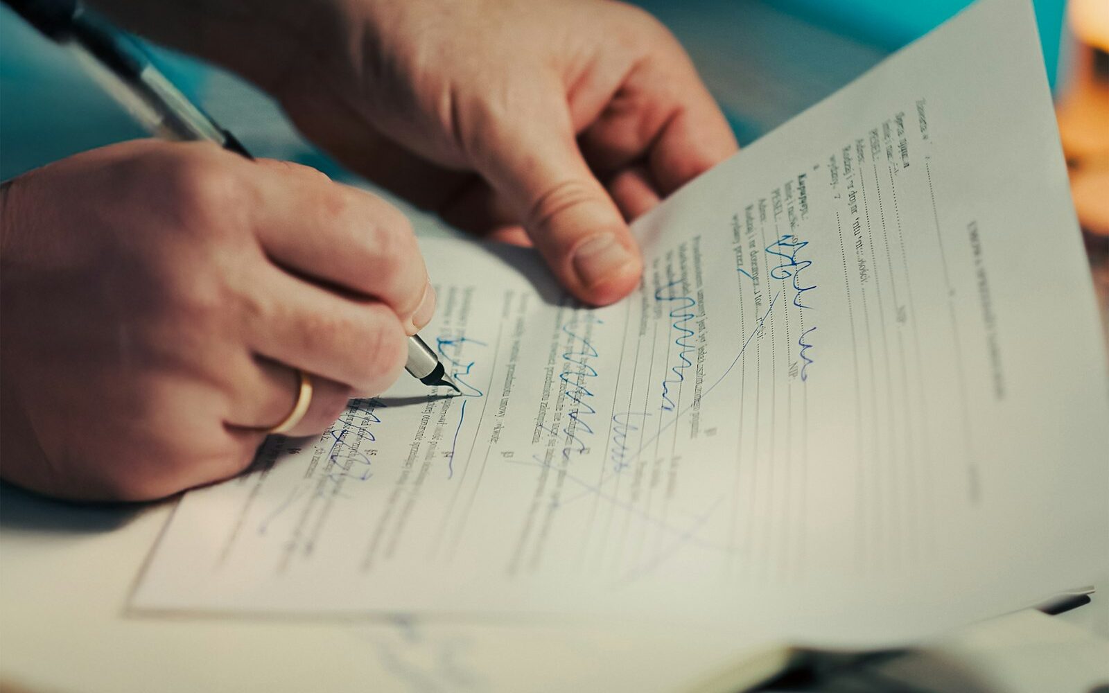 Two people signing a car rental agreement, photographed close up