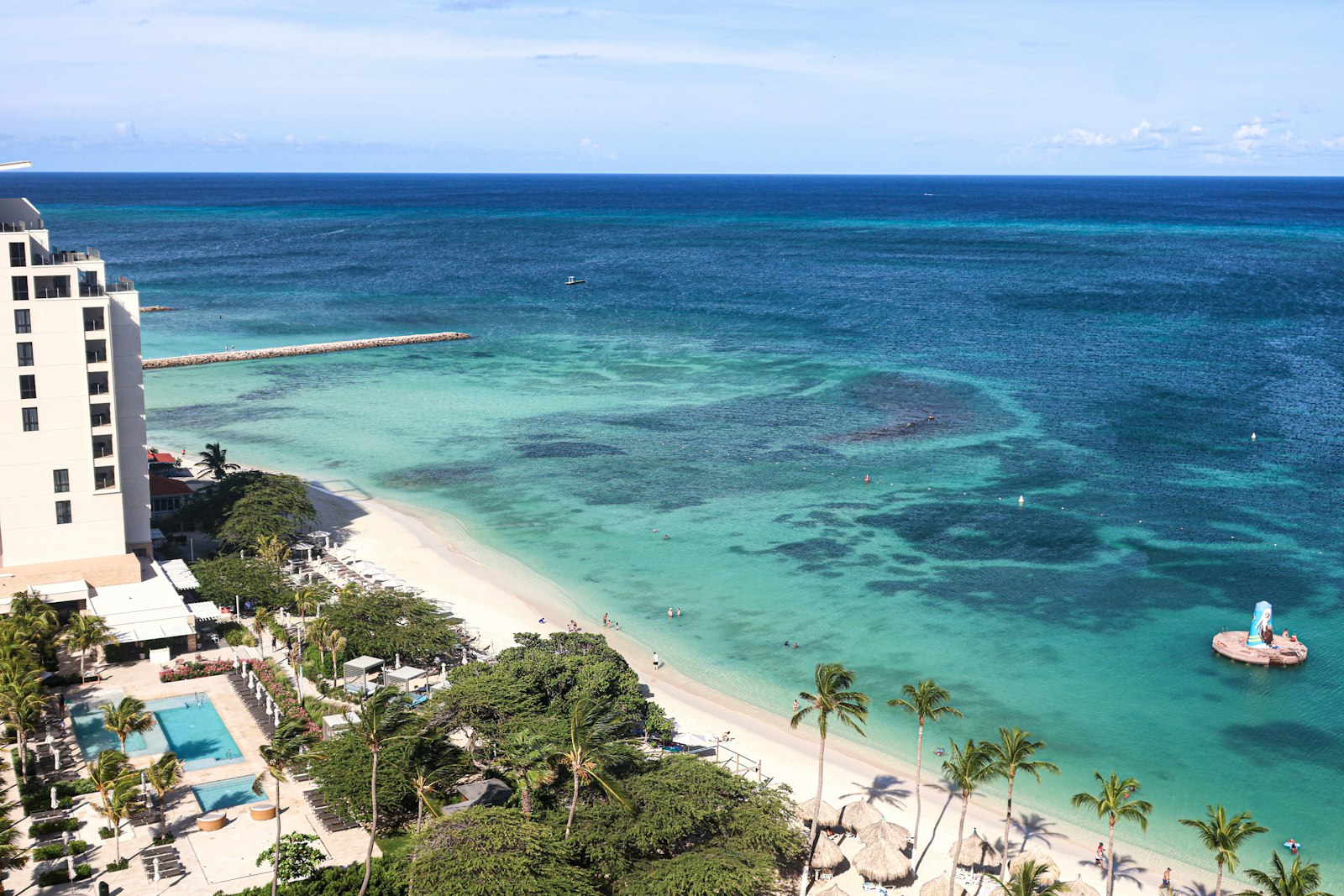 Turquoise beach with palm trees and white sand, similar to Ksamil on the Albanian Riviera